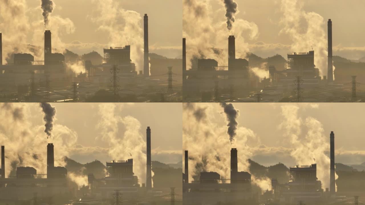 在日出时，一家化工厂的鸟瞰图中，烟囱冒烟，空气污染。环境问题，工作中的世界无人机视图概念。与阿尔法香