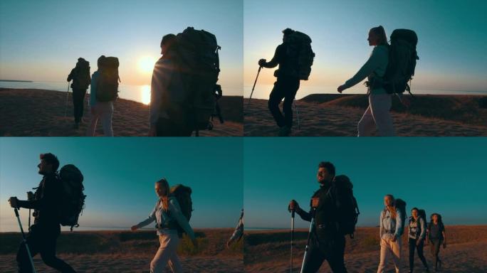 四个背着背包的旅行者在海边的山上行走。慢动作