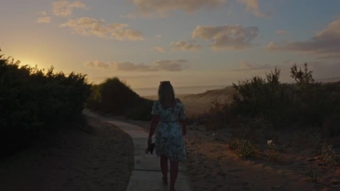 意大利撒丁岛，一个金发女人独自走在海滩上的景色。