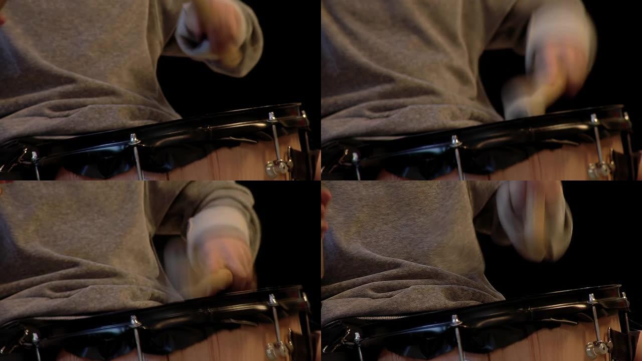 男性鼓手使用槌演奏低音鼓。特写。