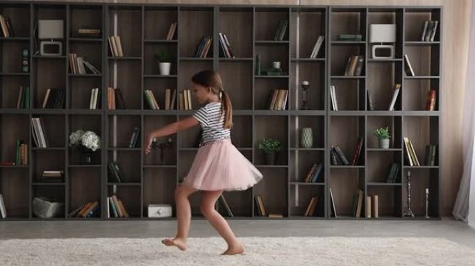 小女孩穿着蓬松的裙子在现代客厅跳舞