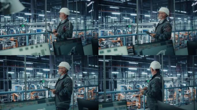 汽车厂: 男汽车工程师戴安全帽，站着使用平板电脑。监控、控制、设备生产。自动机械臂装配线制造电动汽车
