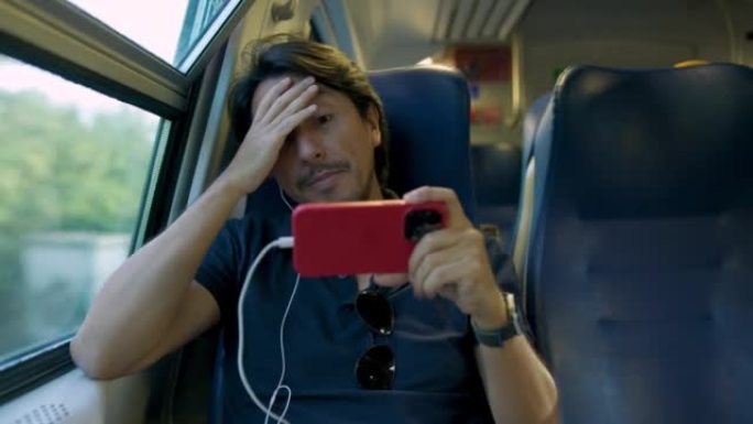 担心的人骑着火车用耳机在智能手机上观看足球比赛