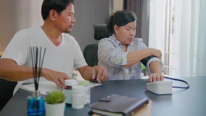 亚洲老年夫妇在家检查血压计和心率