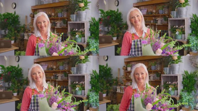 花店商店成熟的女老板拿着一束鲜花的肖像-慢动作拍摄