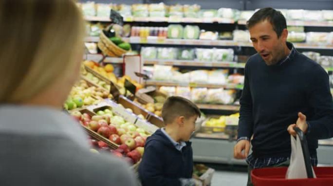 父亲，母亲和儿子的幸福家庭的真实照片在超市一起购物时，选择产品很有趣。
