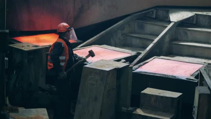 工厂工人正在打击模具中的铜凝固
