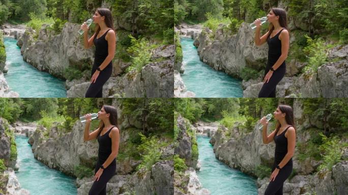 欢快的女游客在山涧享受壮丽的景色，喝水