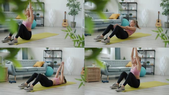 现代公寓瑜伽垫上练习腹肌的女学生慢动作