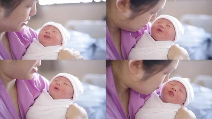 母亲抱着儿子，在分娩后在医院用爱心亲吻新生儿