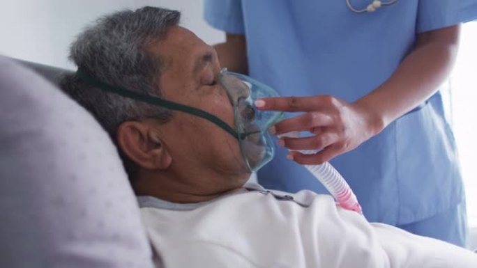 混血女医生协助老人在家卧床使用呼吸机