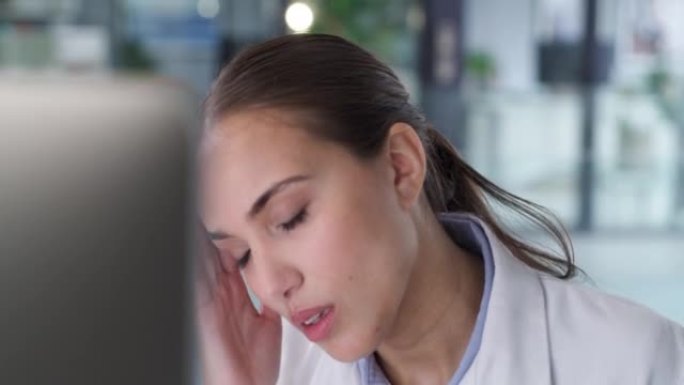 一位年轻医生使用计算机并在现代医院中看起来压力很大的4k视频片段