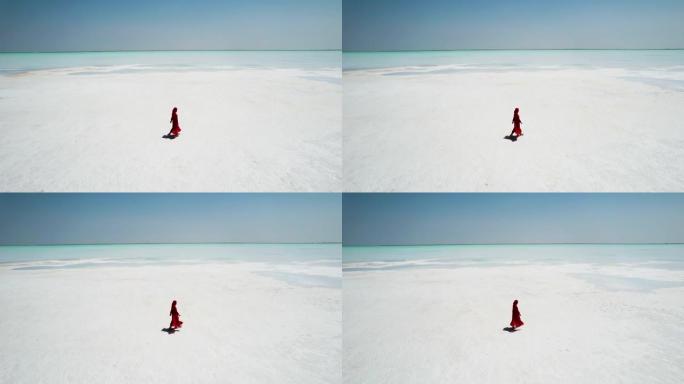穿着红色连衣裙走在盐湖上的女人
