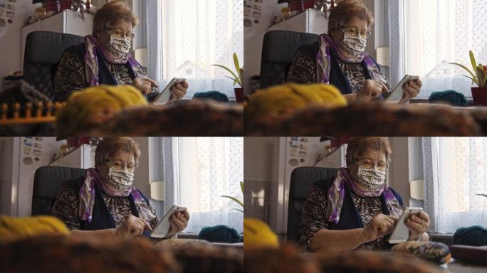 老年妇女在家庭检疫期间戴着防护口罩并使用手机