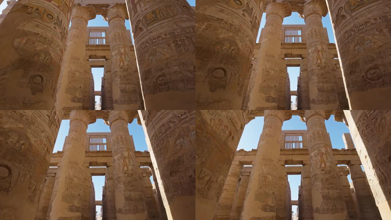 相机在带有古埃及图纸的雄伟圆柱之间移动。万向节高质量镜头。埃及卢克索的卡纳克神庙