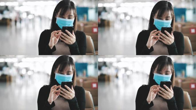 亚洲女性在机场用智能手机戴口罩