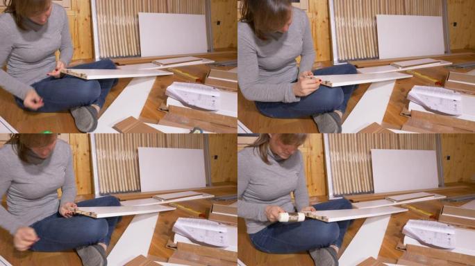 特写: 女性在组装家具时将小木钉粘在木板上。
