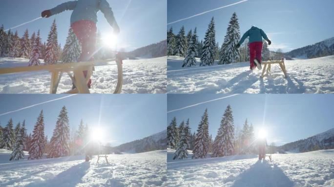 低角度: 面目全非的女人带着木制雪橇跑上雪山。