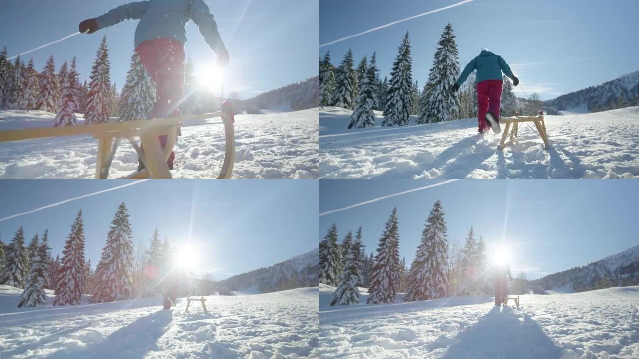低角度: 面目全非的女人带着木制雪橇跑上雪山。