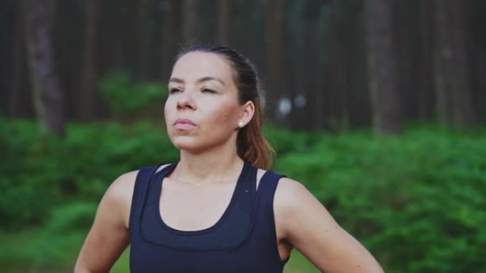 女性黑发运动员休息并欣赏森林自然美景的轨道慢动作镜头