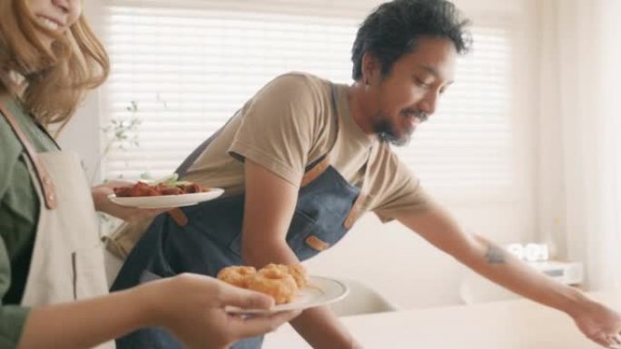 年轻的亚洲男人和女人把美味的食物放在桌子上。