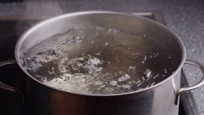 水在炉子上的大铁锅里沸腾。沸腾的水泡。水蒸气上升。超级慢动作镜头