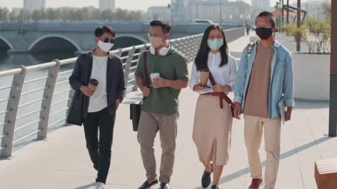 四个亚洲人在夏天沿着河堤漫步