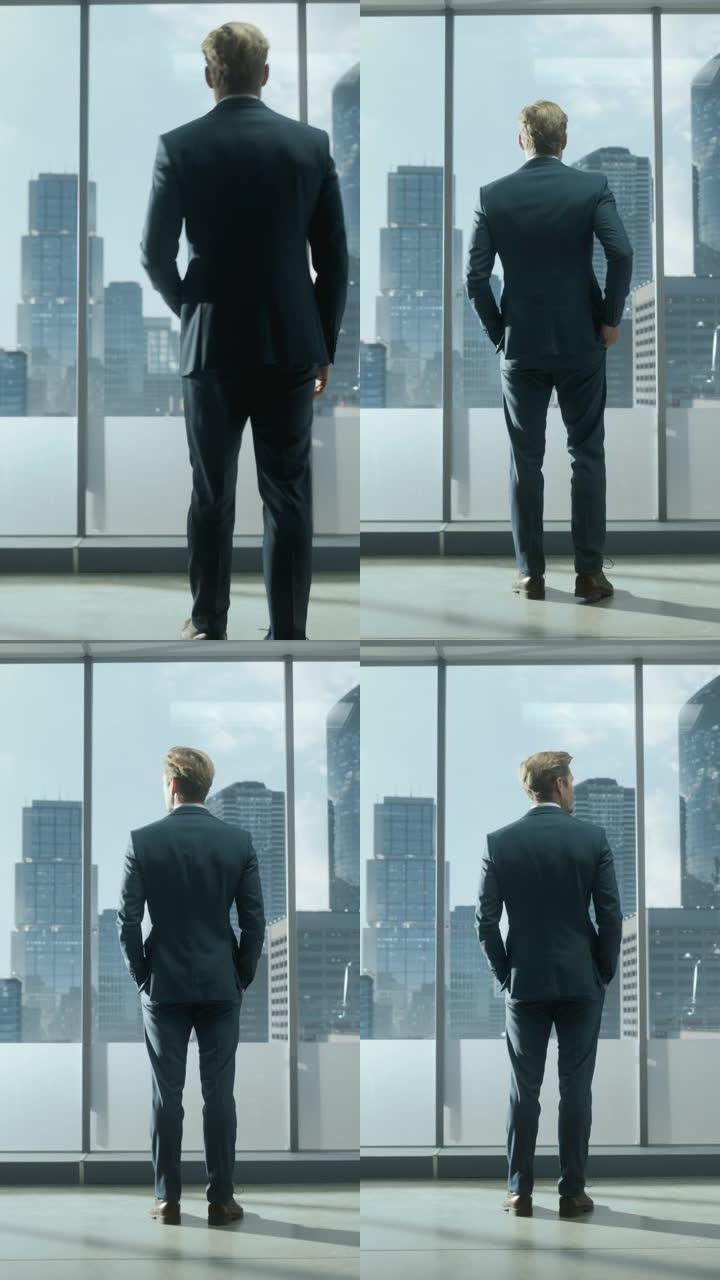 垂直屏幕: 体贴的年轻商人，穿着量身定制的西装，站在现代办公室里，看着窗外的摩天大楼。成功的财务经理