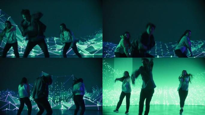 由三名专业舞者组成的多元化小组在工作室进行虚拟制作期间，在带有VFX动画的大Led屏幕前近距离表演嘻