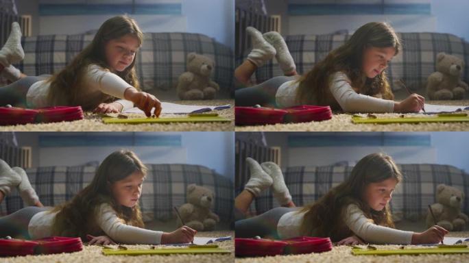 一个可爱的小女孩的电影镜头正在舒适地躺在托儿所舒适的地毯上做家庭作业。学校，教育，学习，舒适，想象力