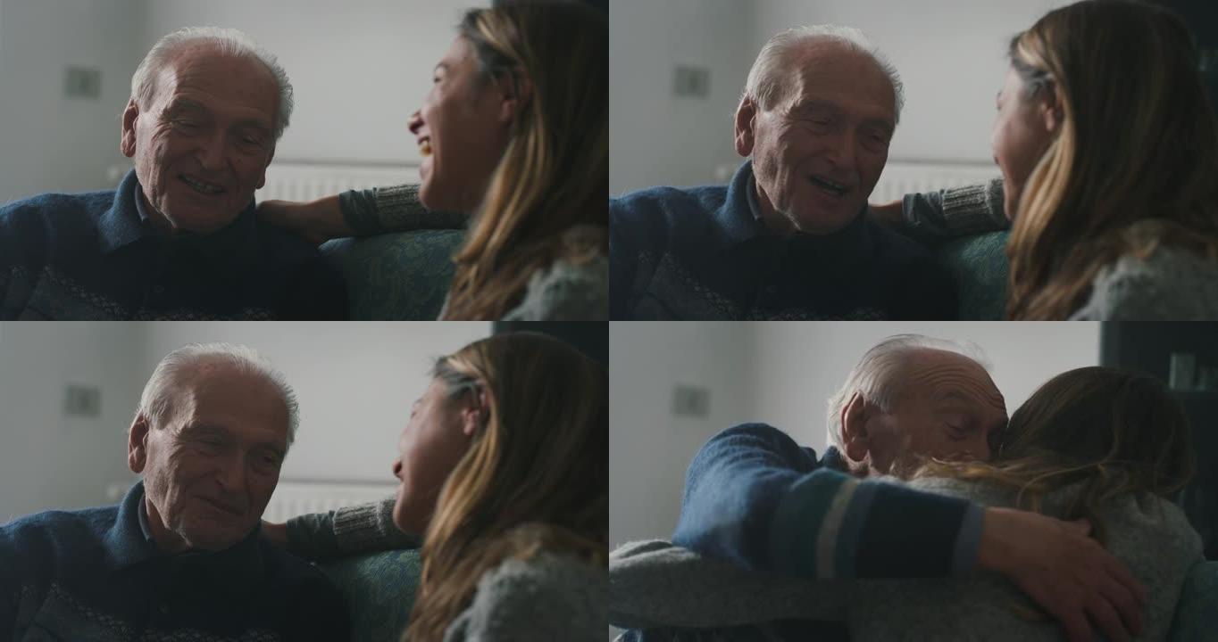 电影拍摄的高级白发祖父和孙女坐在家里的沙发上，一起玩乐，深情地拥抱。概念: 生活，祖父母，世代，爱，