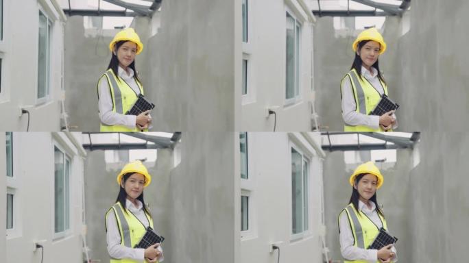 在建筑工地工作并拿着太阳能电池板的蓝领亚洲妇女