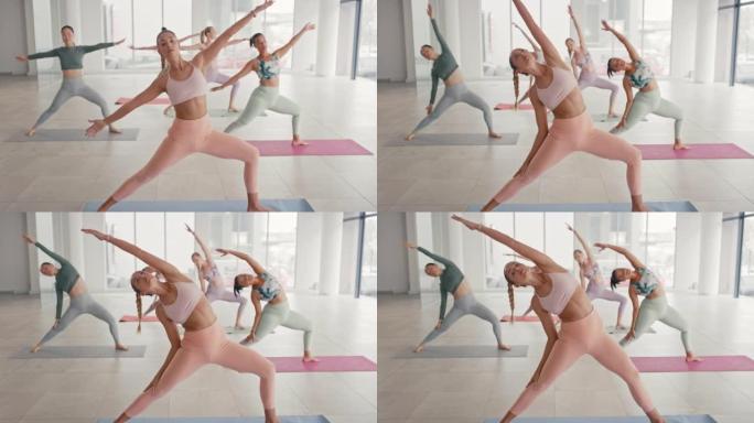一群健康的女性在瑜伽课上练习战士两个姿势。普拉提教练在健康和保健工作室上课，同时伸展关节以实现身体身
