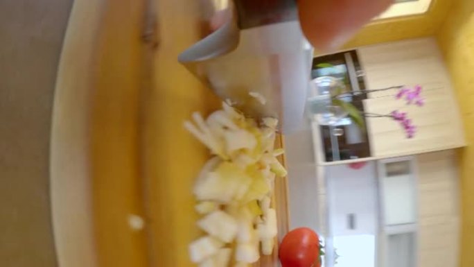 垂直: 用钢刀在木板上切碎洋葱的详细镜头。