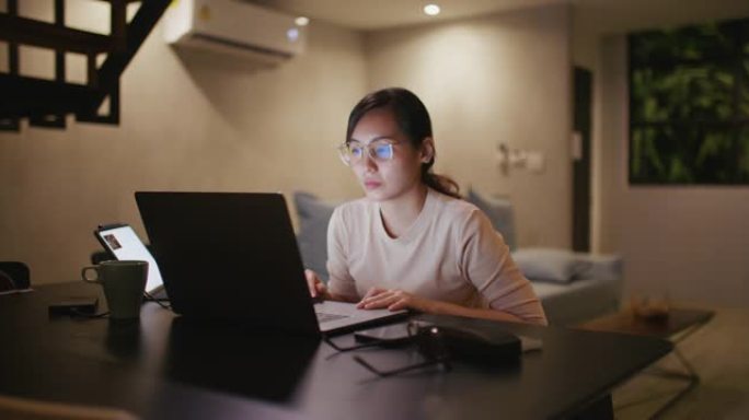 亚洲女性晚上使用笔记本电脑
