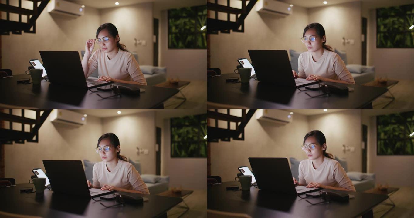亚洲女性晚上使用笔记本电脑