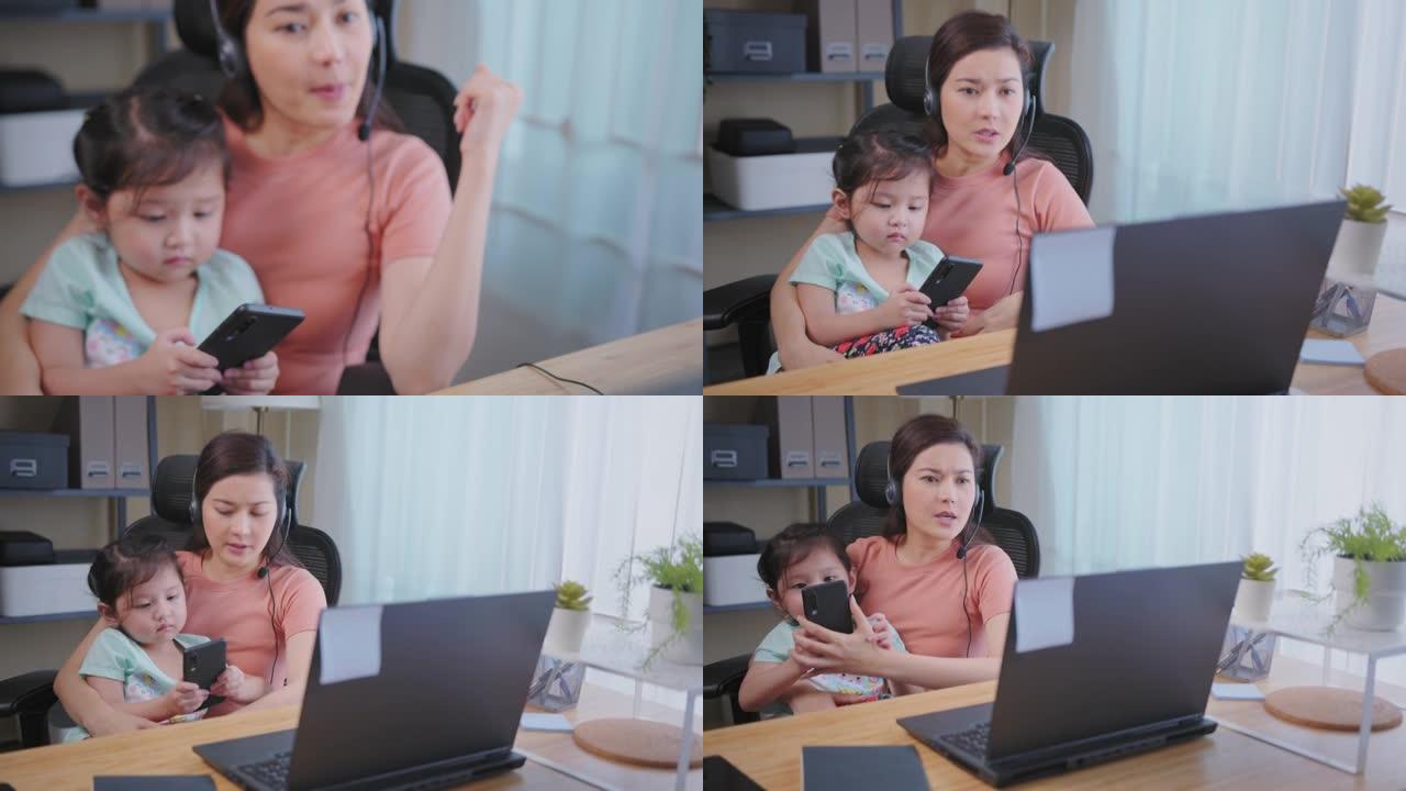 亚洲母亲视频会议，同时在家照顾女儿。远程工作中断概念。