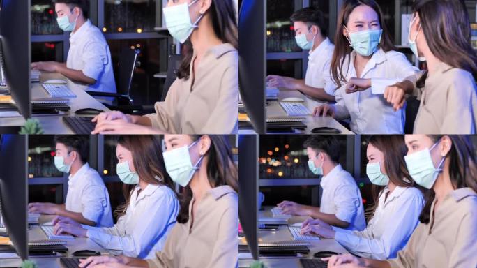 新型冠状病毒肺炎大流行后，亚洲女商人戴着口罩，在办公室用肘部颠簸打招呼，晚上工作到很晚。在 “新” 