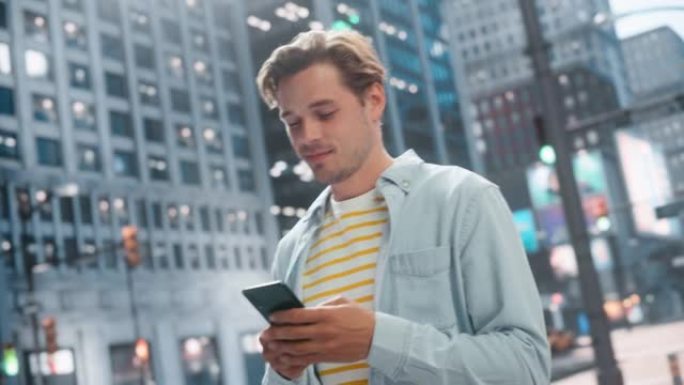 一个英俊的年轻人穿着便服，在城市街道上使用智能手机的肖像。大城市中的时尚男性与人们在线联系，消息传递