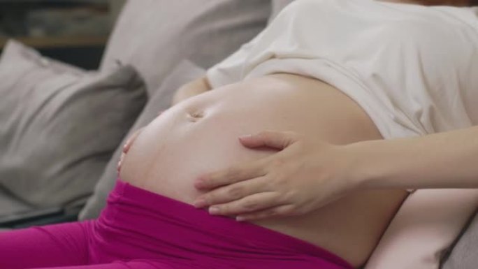 孕妇在腹部涂抹奶油的特写镜头。妊娠纹问题，保湿