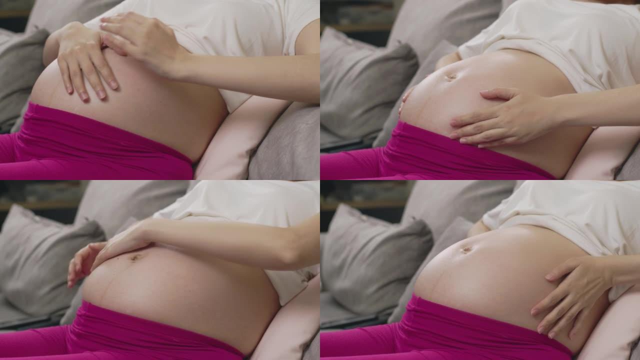 孕妇在腹部涂抹奶油的特写镜头。妊娠纹问题，保湿