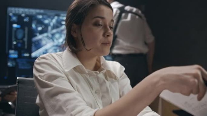 一个穿着白衬衫的年轻女子正在计算机上工作