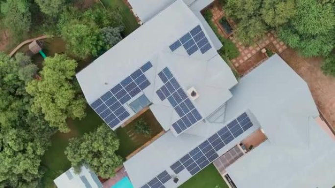 郊区房屋屋顶的圆形鸟瞰图，屋顶上有大量的光伏太阳能电池板，可在屋顶上提供能量