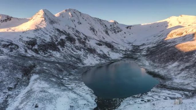 日出的光芒刚刚照亮了雪山，湖水仍静静地躺在雪山的怀抱中