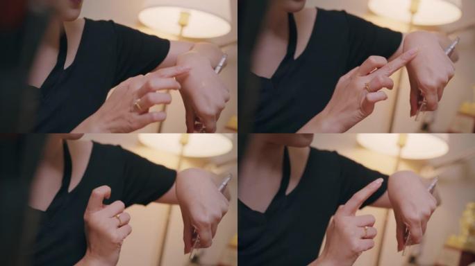 亚洲女性youtube影响者记录教学化妆显示口红颜色在手上。