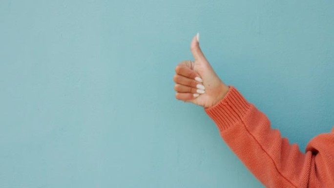 竖起大拇指，喜欢在工作室或蓝色墙壁背景上手工表情符号模型。具有 “是”，“谢谢” 或 “支持” 标志