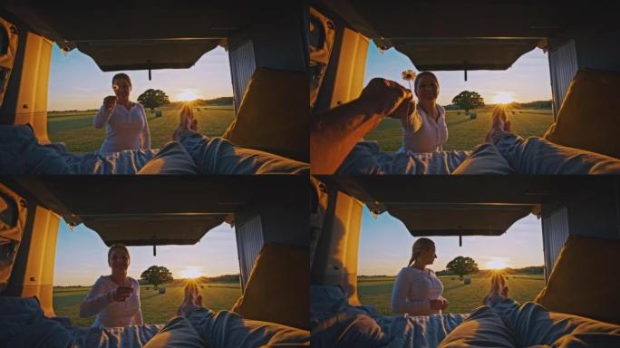 POV女人给她的男朋友一个雏菊，她的男朋友在阳光明媚的日子躺在露营车里