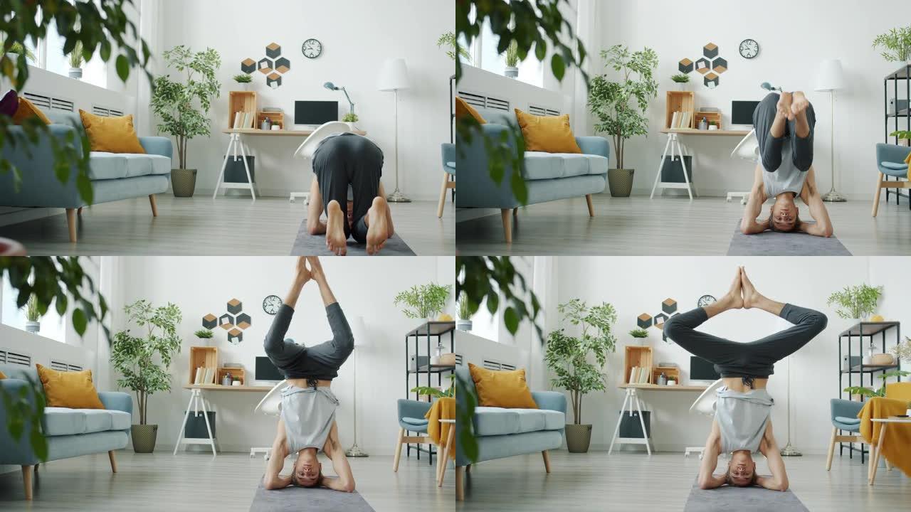 经验丰富的瑜伽学生在公寓里独自做倒立训练的慢动作肖像