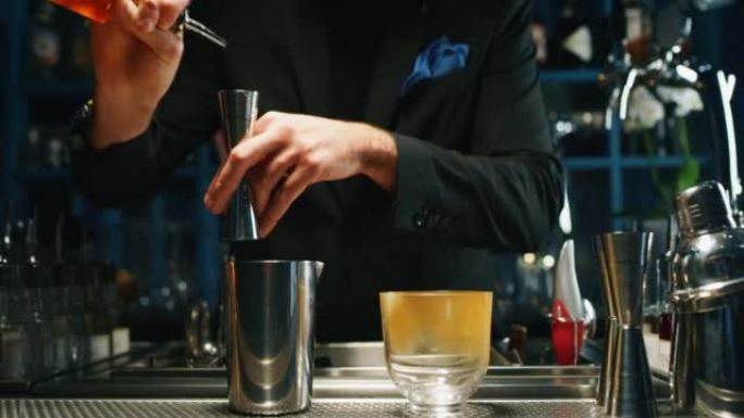 专业调酒师正在酒吧或迪斯科俱乐部为顾客准备含冰块的酒精鸡尾酒。