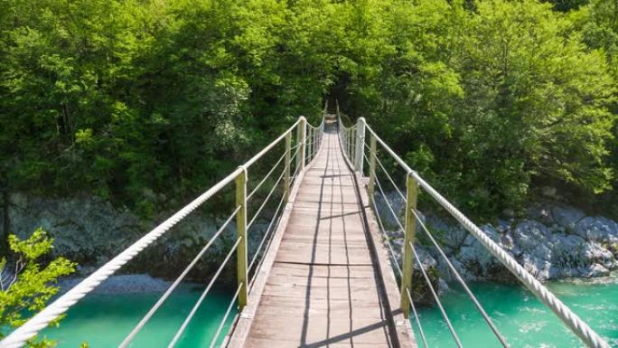 穿越绿松石河上的木制吊桥